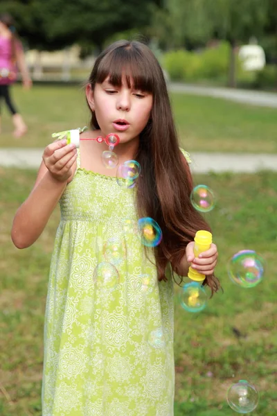 Adorável Menina Feliz Sentada Grama Soprando Bolhas Sabão — Fotografia de Stock