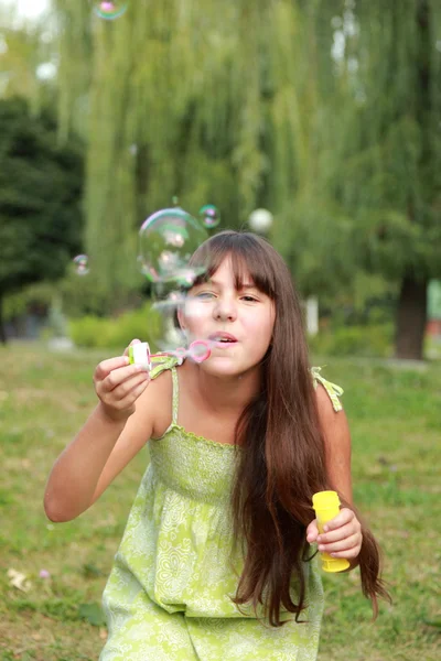 Kleines Mädchen pustet Seifenblasen — Stockfoto