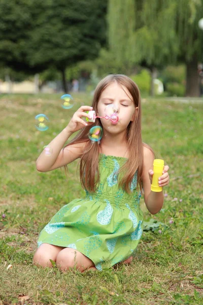 Menina bonita em jogado com bolhas de sabão — Fotografia de Stock