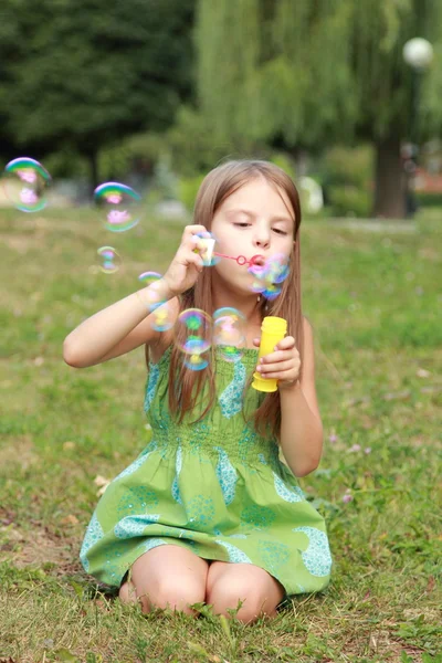 Klein meisje in het park met zeepbellen spelen — Stockfoto