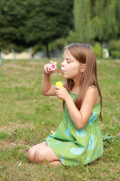 Sabun köpüğü ile parkta oynarken küçük kız — Stok fotoğraf