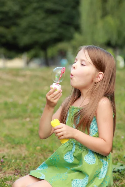 Niña jugando en el parque con burbujas de jabón — Foto de Stock