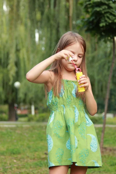 Menina bonita em jogado com bolhas de sabão — Fotografia de Stock