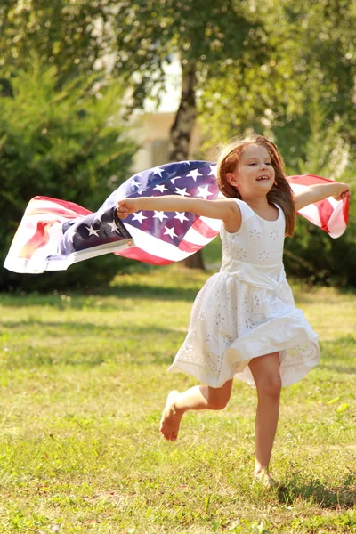 女孩抱着一个大型美国国旗 — 图库照片