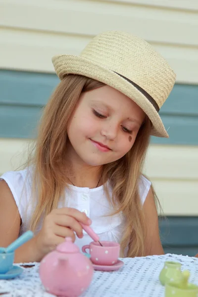 Kleines Mädchen spielt mit Kindergeschirr — Stockfoto