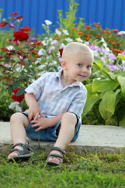 Cute little boy sitting on the track — Stock Photo, Image