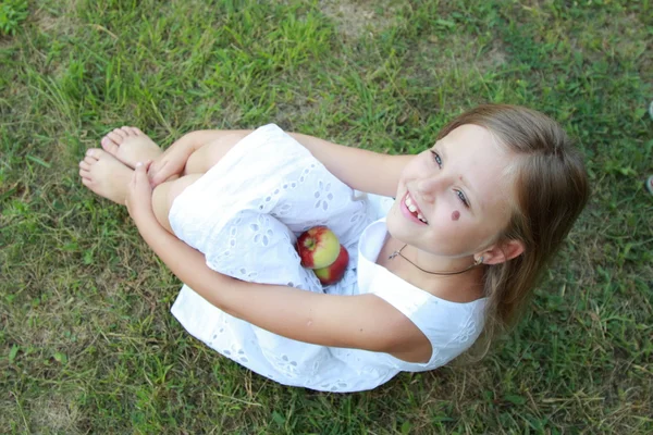 Kleines Mädchen sitzt auf Gras — Stockfoto