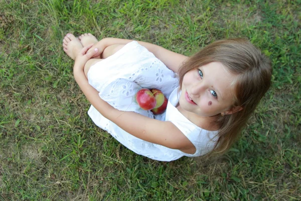 Çimlerde oturan küçük kız — Stok fotoğraf