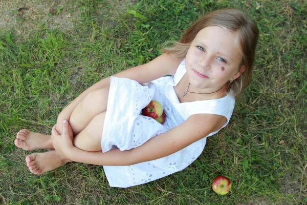 Kleines Mädchen sitzt auf Gras — Stockfoto