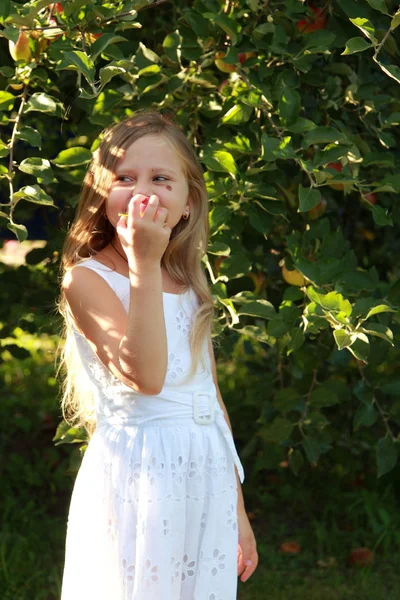 Chica en un vestido blanco comiendo manzana — Foto de Stock