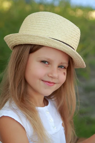 Niña con sombrero sonriendo al aire libre — Foto de Stock