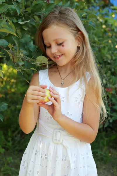 Flicka sliter av äpplen från trädet — Stockfoto