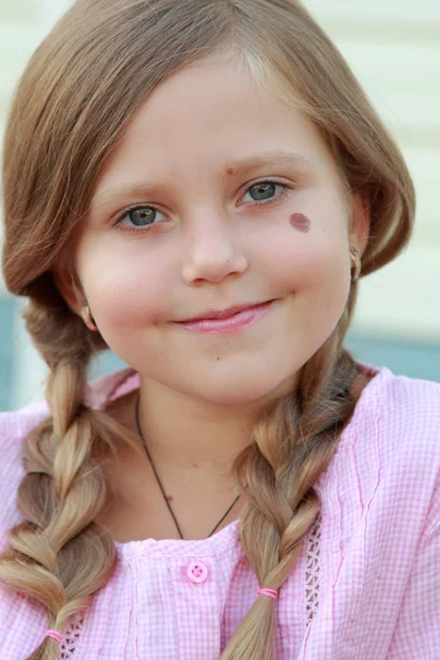 Menina com duas tranças em uma jaqueta rosa — Fotografia de Stock