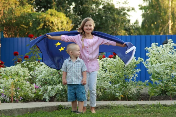 Meisje met een jongen die houdt een vlag van de Europese Unie — Stockfoto