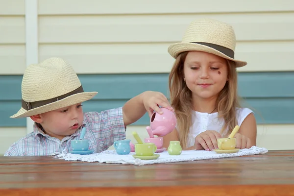 Frère et sœur jouant avec la vaisselle des enfants — Photo