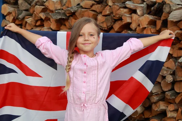 Little girl holding a big UK flag Royalty Free Stock Images