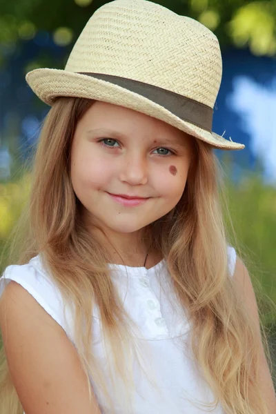 Little blond girl sitting on a bench — Stock Photo, Image