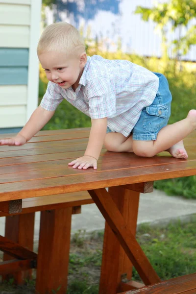 Child climbed up with his feet on the table — Stock Photo, Image