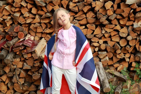 Joyful menina bonita segurando uma grande bandeira da Grã-Bretanha — Fotografia de Stock