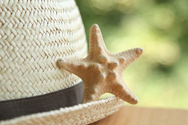 Straw hat and a little starfish blurred background — Stock Photo, Image