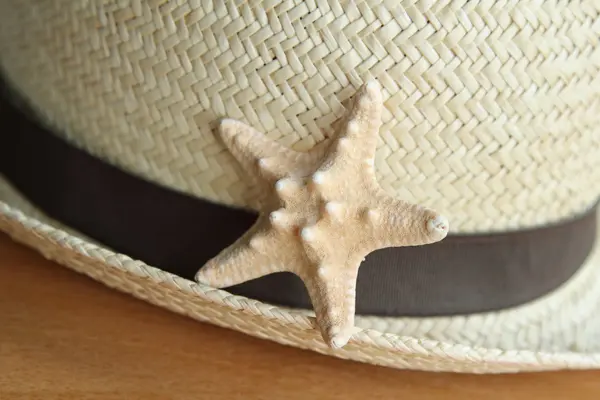 Zomer stro hoed en een beetje starfish houten achtergrond — Stockfoto