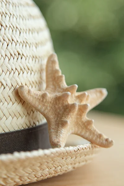 Straw hat and starfish on wooden background — Stock Photo, Image