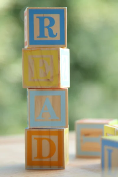 Слово "Чтение" цветных кубиков для детей дошкольного возраста — стоковое фото