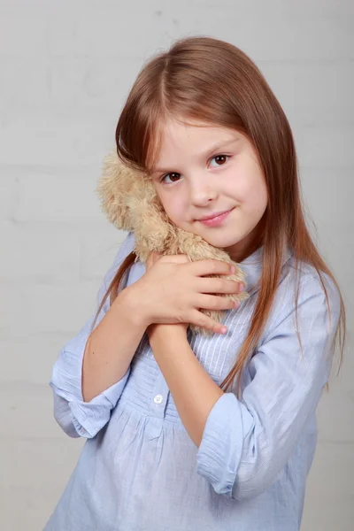Söt flicka kramas lite brun nallebjörn — Stockfoto
