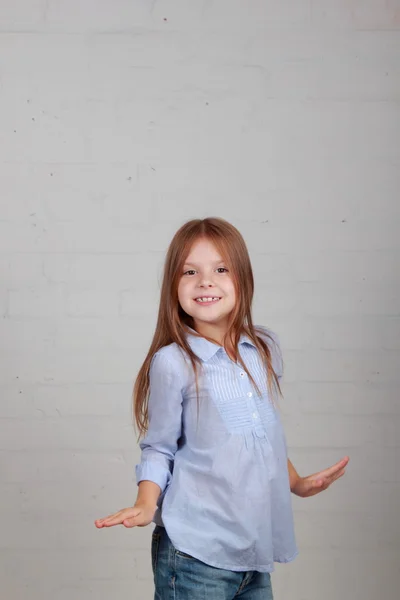 Emotionele kind dansen en springen op een grijze achtergrond — Stockfoto