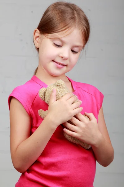 Liten flicka som håller i en nalle — Stockfoto