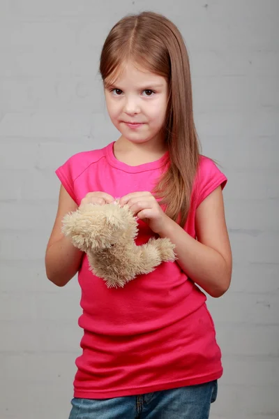 Kleines Mädchen umarmt Bärenspielzeug — Stockfoto