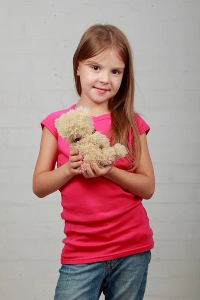 Маленькая девочка обнимает медвежью игрушку — стоковое фото