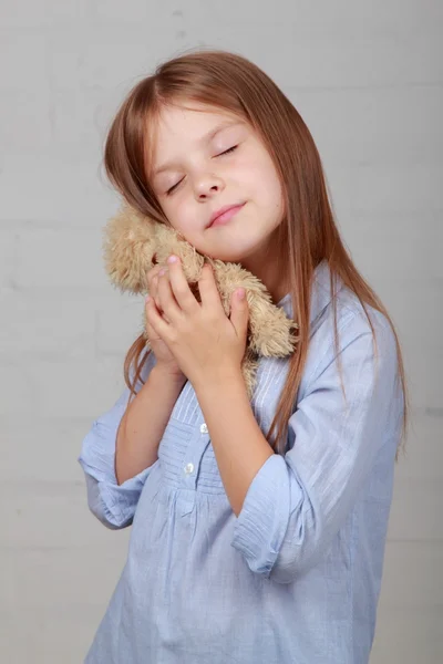 Lille pige kramme bjørn legetøj - Stock-foto