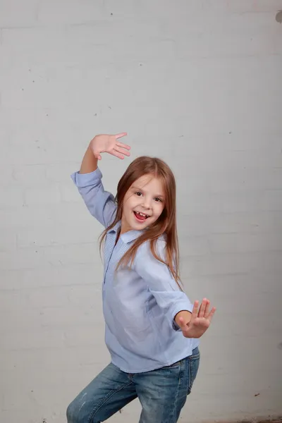 Emotional child dancing and jumping on a gray background — Stock Photo, Image