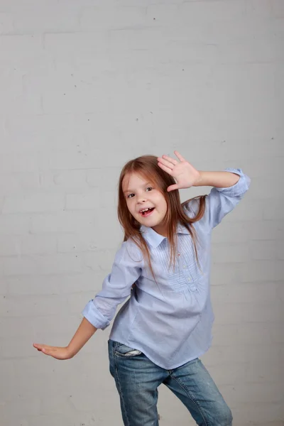 Emocional niño bailando y saltando sobre un fondo gris —  Fotos de Stock