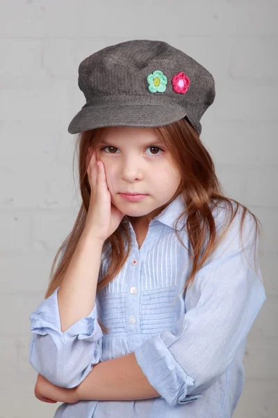 Verschrikkelijke piraat meisje in shirt en hoed op een grijze achtergrond — Stockfoto