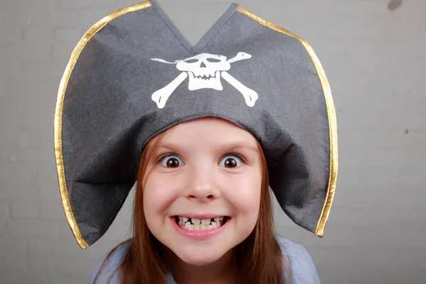 Terrible pirate girl in shirt and hat on a gray background — Stock Photo, Image