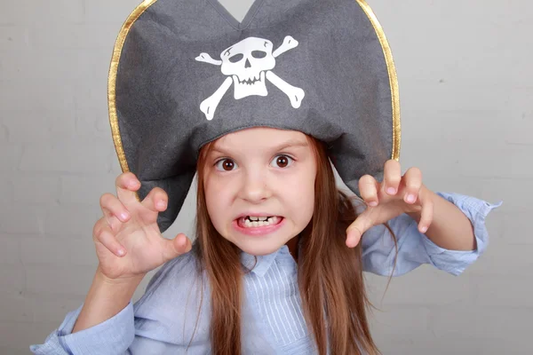 Fruktansvärda pirat flicka i skjorta och hatt på en grå bakgrund — Stockfoto
