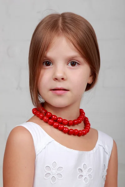 Bild av en vacker flicka med röda pärlor — Stockfoto