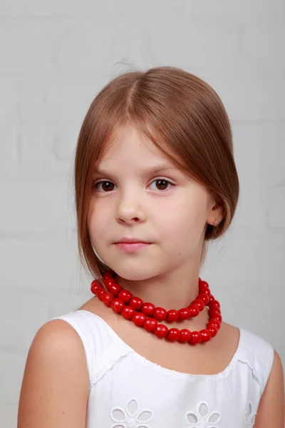Bild eines schönen Mädchens mit roten Perlen — Stockfoto