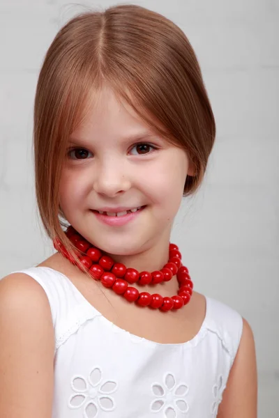 Bild av en vacker flicka med röda pärlor — Stockfoto
