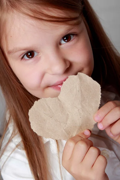 女孩抱着一颗小小的纸的心 — 图库照片