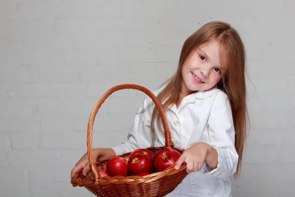 女孩抱着柳条编织的篮子，用苹果 — 图库照片