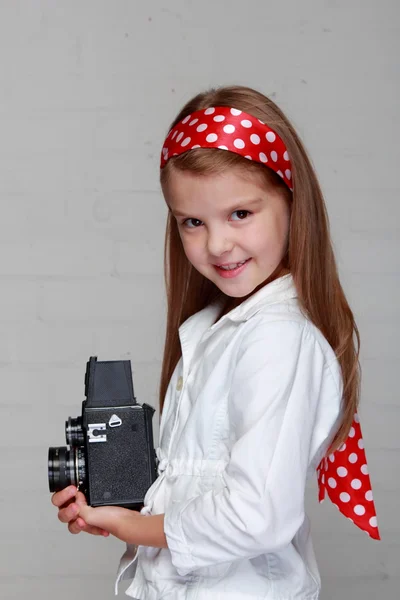 Girl holds a vintage camera — Stock Photo, Image