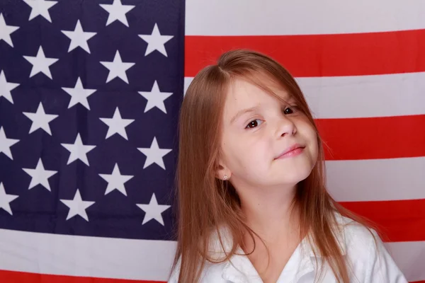 Meisje tegen de achtergrond van de Amerikaanse vlag — Stockfoto