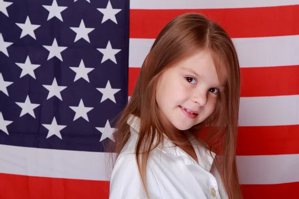 Mädchen vor dem Hintergrund der amerikanischen Flagge — Stockfoto