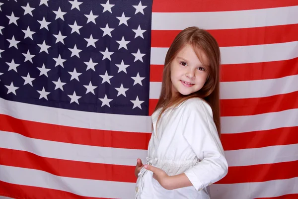 Mädchen vor dem Hintergrund der amerikanischen Flagge — Stockfoto