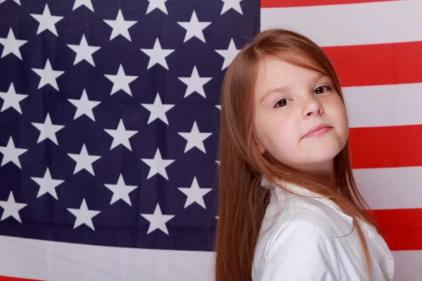 Mädchen vor dem Hintergrund der amerikanischen Flagge — Stockfoto