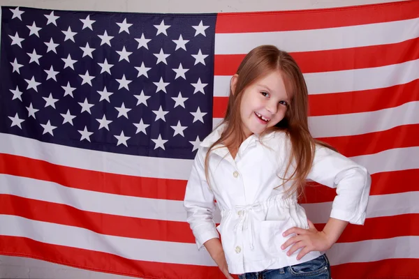 Mädchen vor dem Hintergrund der amerikanischen Flagge — Stockfoto