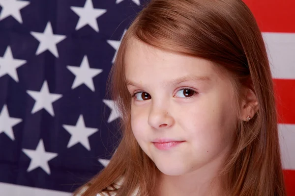 Mädchen vor dem Hintergrund der amerikanischen Flagge — Stockfoto